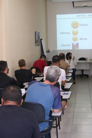 Agentes sentados na sala de aula acompanham curso #paratodosverem