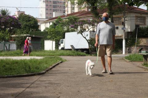 Idoso passeia cachorro em praça. #Paratodosverem