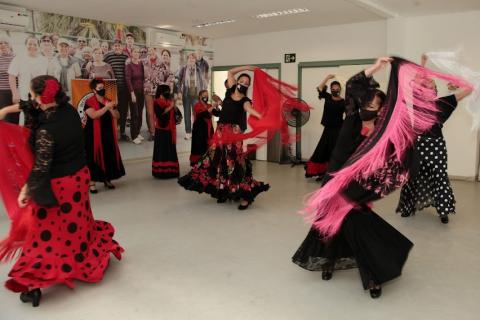 mulheres dançam flamenco se movimentando no salão. #paratodosverem
