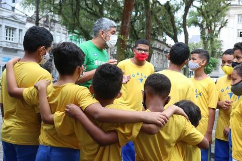 equipe de jovens reunidos e abraçados. #paratodosverem