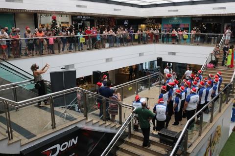 apresentação do coral e público em torno assistindo. #paratodosverem