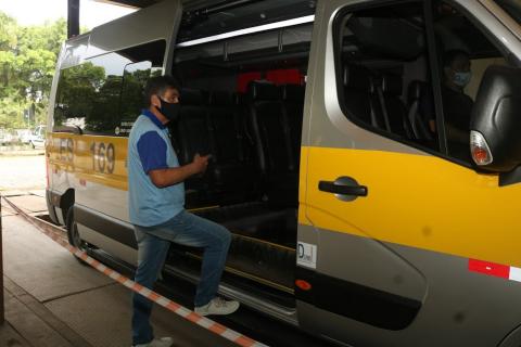 Homem aponta para dentro da van que está aberta #paratodosverem