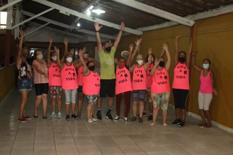 grupo posa para foto com todos em pé e os braços para cima. #paratodosverem