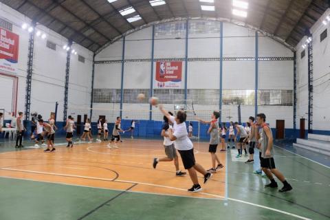alunos estão em quadra praticando fundamentos do vôlei. #paratodosverem