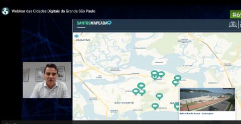 tela de notebook como secretário de planejamento Fábio Ferraz à esquerda e imagem de mapa de SAntos. #paratodosverem