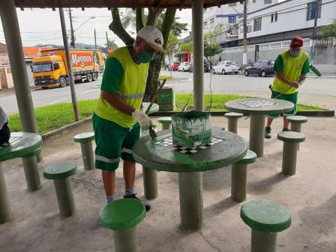 operários atuam em mesa com tabuleiro pintado #paratodosverem 