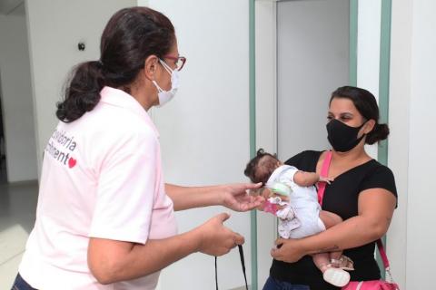 voluntária entrega copo a mulher #paratodosverem