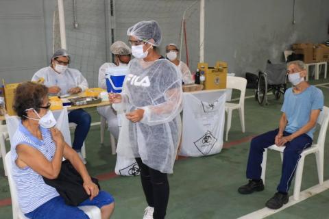 enfermeira se prepara para vacinar mulher #paratodosverem 