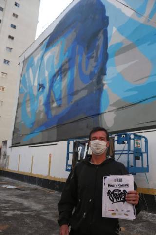 artista na frente do grafite #paratodosverem