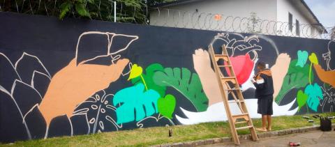 Artista desenha o grafite no muro. #paratodosverem