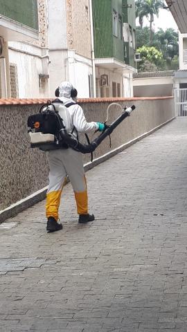 Homem faz nebulização em corredor de prédio #paratodosverem