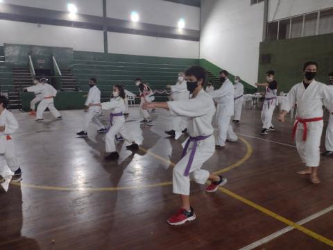 Atletas fazendo apresentação de caratê em ginásio #paratodosverem