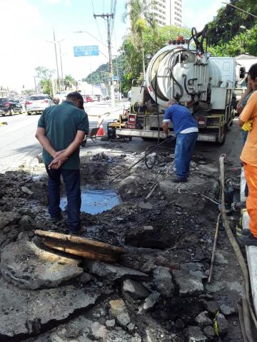 homem observa buraco em via com caminhão a frente #paratodosverem