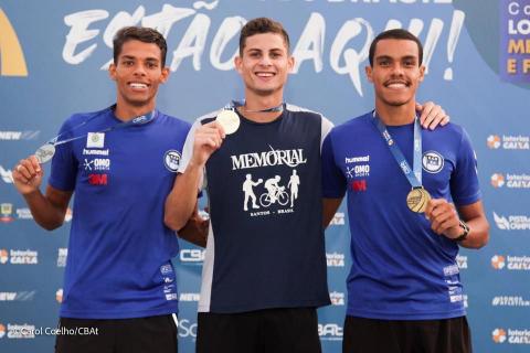 atletas no pódio exibem medalha #paratodosverem