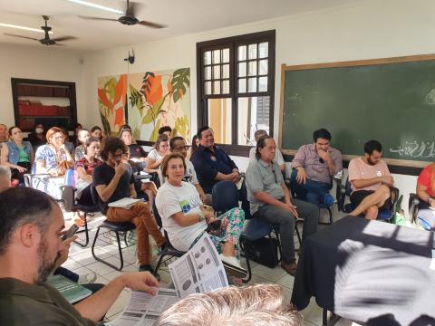 pessoas estão sentadas em sala assistindo palestra