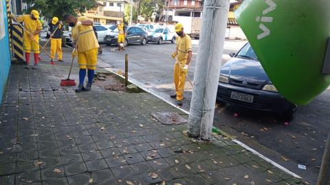 Trabalhadores realizam serviço de limpeza em calçada #paratodosverem
