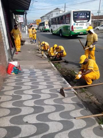 Trabalhadores fazem raspação e capinação na calçada #paratodosverem