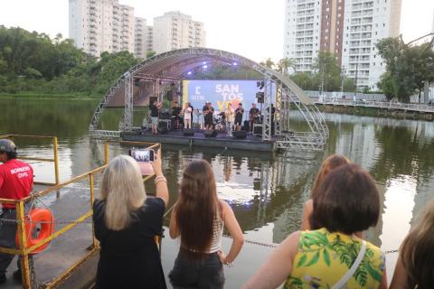 banda em um palco sobre uma lagoa #paratodosverem