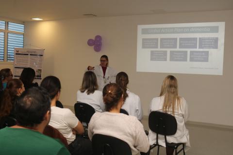 pessoas sentadas em auditorio assistem palestra. #paratodosverem 
