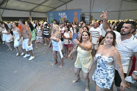 público dança animada sob tenda. #paratodosverem
