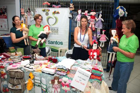 voluntárias na frente de barraca de artesanato #pracegover