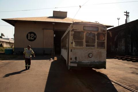 bonde ao lado da garagem com técnico caminhando ao lado #pracegover