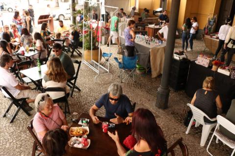 pessoas sentadas comendo no festival #pracegover 