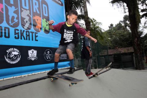 Dois meninos se preparam para descer rampa na pista de skate