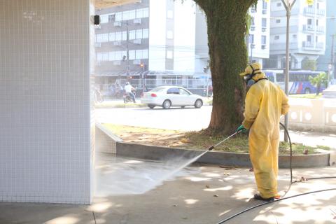 operário limpa calçada na frente de banheiro da orla #paratodosverem 