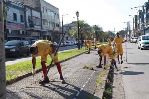 operários capinam calçada #paratodosverem