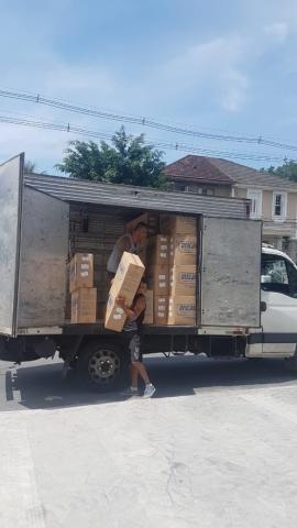 Homens retiram caixas de caminhão. #Paratodosverem