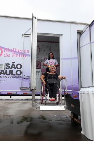 Mulher em cadeira de rodas é elevada em plataforma #pracegover 