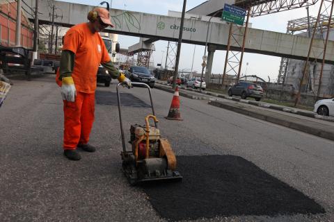 operário tapa buraco com máquina #pracegover