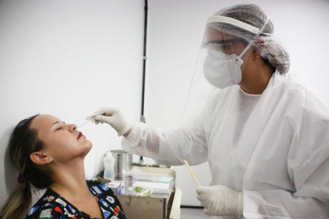 profissional de saúde faz teste em mulher #paratodosverem