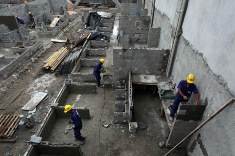 visão aérea de três operários atuando na obra #pracegover 