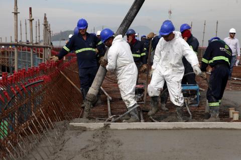 operáios mexem com poste durante a obra #pracegover