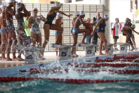 Crianças se preparam para pular na piscina. #pracegover