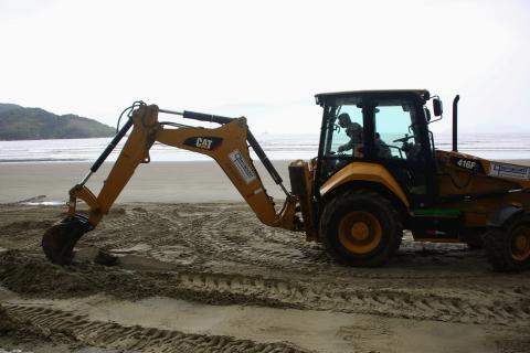 escavadeira retira detritos na areia #paratodosverem