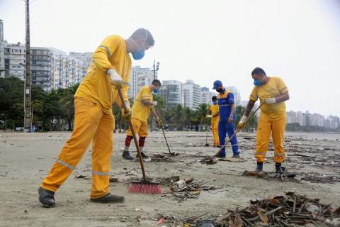 operários varrem detritos na areia #paratodosverem 