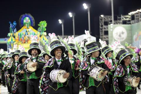 Bateria de escola de samba em desfile de carnaval. #Pracegover