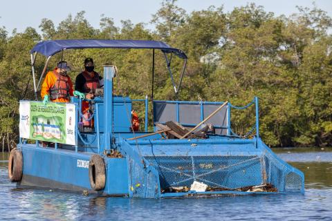 barco navega recolhendo o lixo #paratodosverem