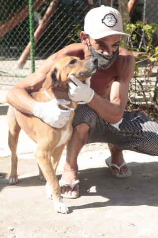 Homem está abraçado ao seu cão. #Paratodosverem