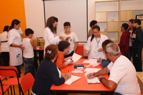 Técnicos estão sentados em mesa com papéis #pracegover