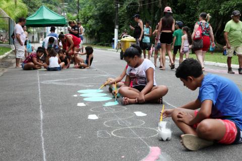 crianças pintam o chão #pracegover 