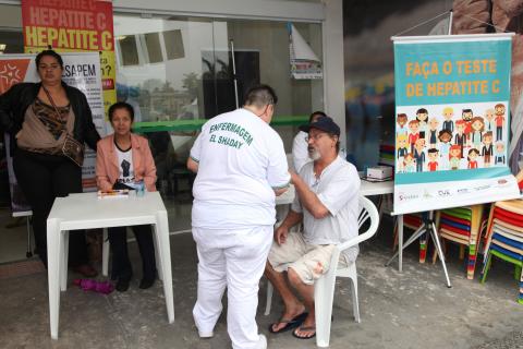 enfermeiro conversa com homem sentado #pracegover