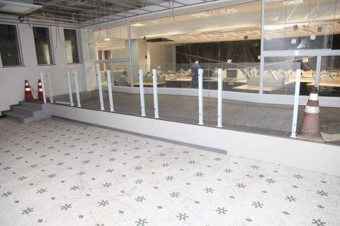Imagem mostra o antigo piso em mosaico característico do Paço e, ao fundo, um grande telão coberto com plástico preto. #Pracegovercegover