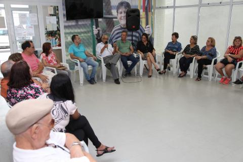 Abissair fala para idosos sentados em círculo ao lado #pracegover 