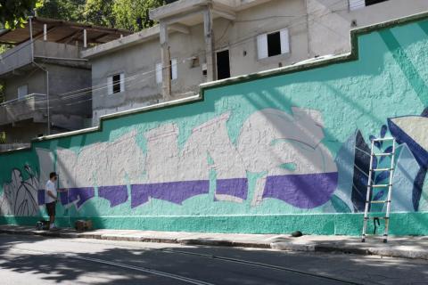 Grande muro onde se lê Marias. Ao lado direito, uma pessoa está pintando as letras. #Paratodosverem