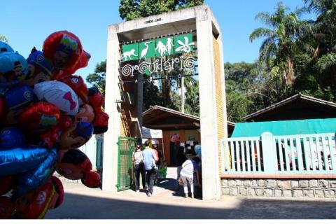 Fachada do Orquidário Municipal com balões infantis no primeiro plano. 