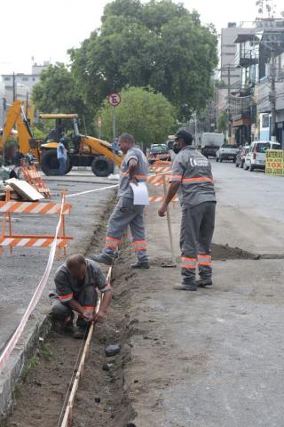 Operários constróem sarjeta ao lado de canteiro central. #Paratodosverem